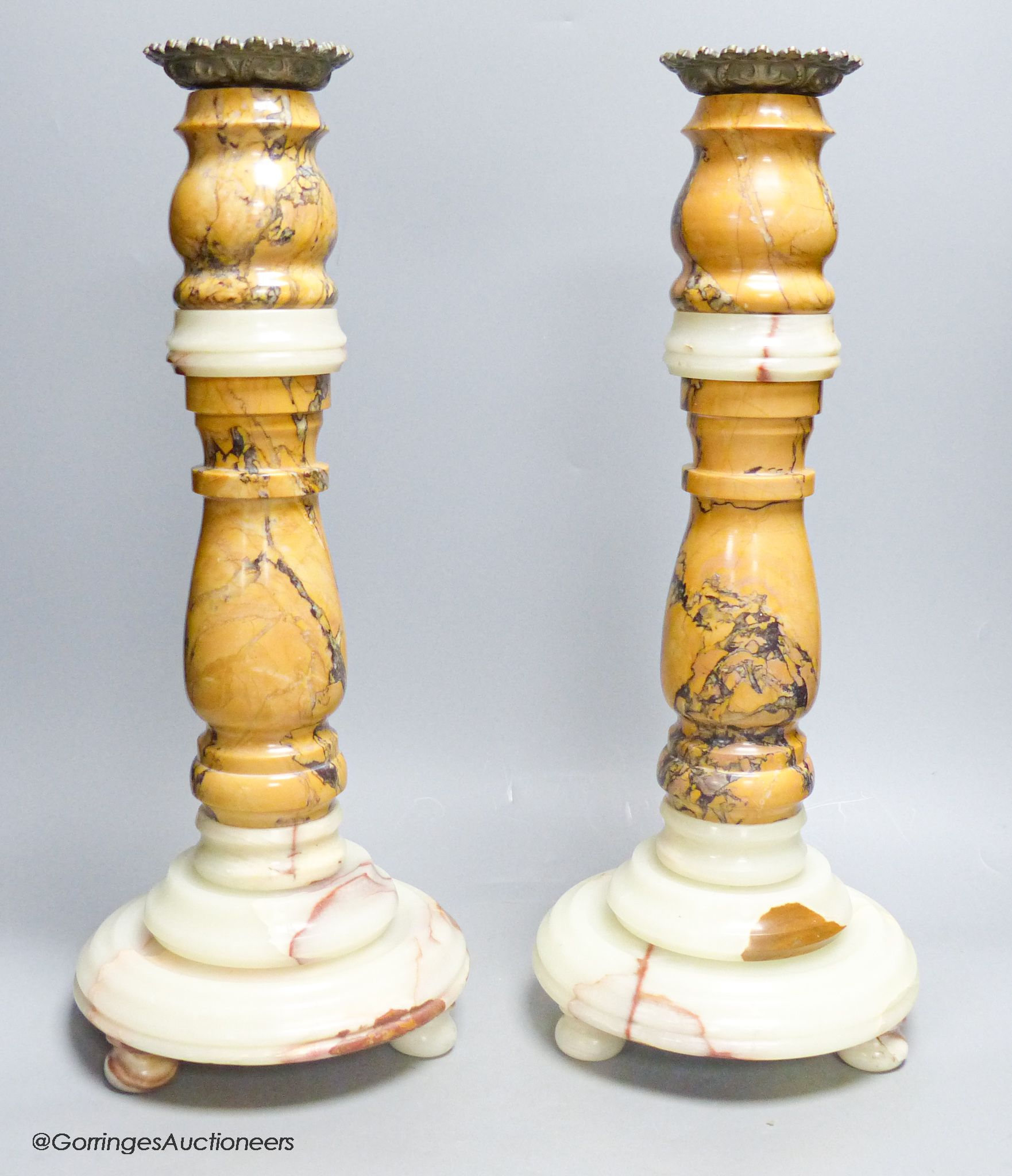 A large pair of variegated marble candlestands